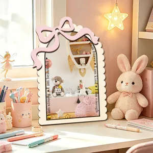 Close-up detail of the wooden decorative mirror featuring a pink bow and engraved text.