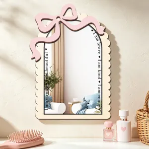 Close-up detail of the decorative wooden wall mirror with cute pink bow and inspiring text.
