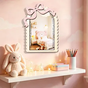 Wooden wall mirror detail showing pink bow design and motivational quotes for kids bedroom decor.