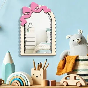 Detailed view of wooden arched wall mirror with cute pink bow and motivational texts.