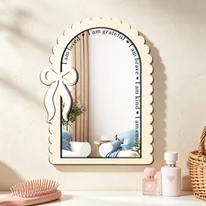 Close-up of wooden arch wall mirror with bow design and inspiring quotes for bedroom decor.
