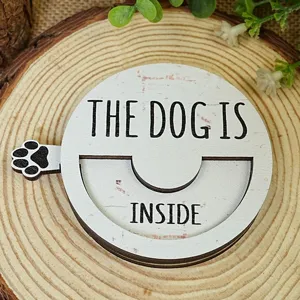 Wooden pet door sign detail featuring text and cute paw print on natural log slice.