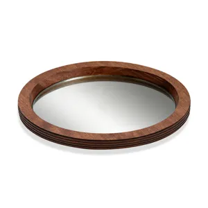 Gros plan du plateau miroir en bois rond, bordure multicouche et fond réfléchissant.