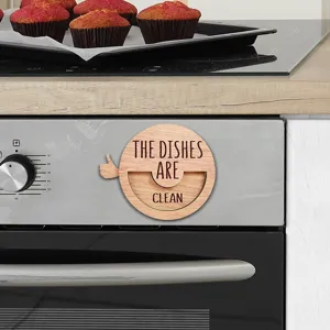 Close-up detail shot of a wooden dishwasher clean dirty magnet sign mounted on kitchen stove.