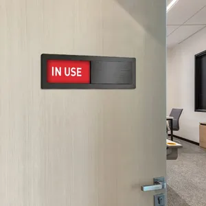 Office sliding door sign detail showing red in use status indicator mounted on wooden door.