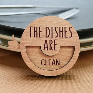 Close-up detail shot of the wooden dishwasher status magnet sign with text and thumb.