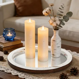 Détail de la scène d'un plateau à bougies en bois avec miroirs, bougies et fleurs séchées.