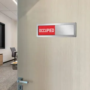 Sliding door status sign detail showing smooth metal brushed finish and clear red text.