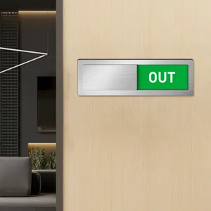 Detail shot of the sliding acrylic door status sign with OUT indicator and metal brushed frame.