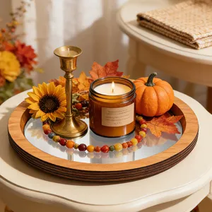 Détail du plateau miroir en bois avec décoration d'automne, bougie et citrouille.