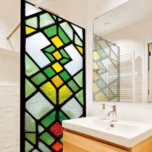 Stained glass window film detail showing geometric colorful pattern in a modern bathroom setup.