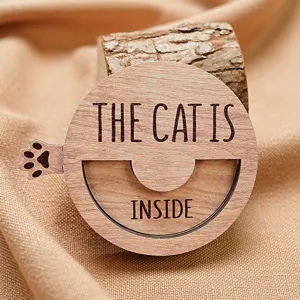 Detailed view of wooden magnetic pet status sign with cat text and rotating design.