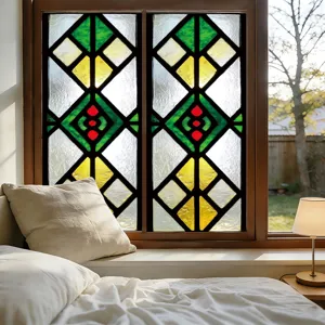 Detail shot of stained glass window film with geometric pattern in cozy bedroom setting.