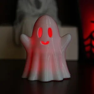 Detailaufnahme einer leuchtenden Halloween-Geist-Dekoration mit stimmungsvollem rotem Licht.