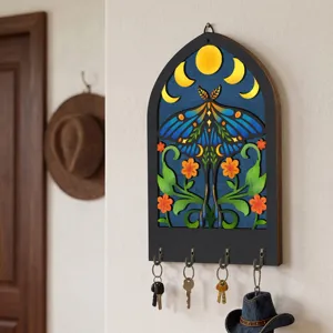 Detailed view of boho wooden wall key holder with moon and moth art decor and practical hooks.