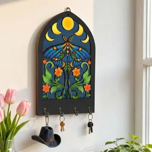 Close-up detail of the bohemian wooden key holder featuring mystic moth and moon phases.