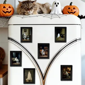 Vue rapprochée de cadres photo magnétiques fantômes 3D d'Halloween sur le frigo rétro blanc.
