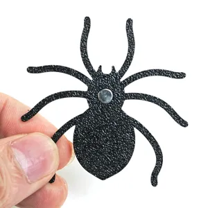 Detailed view of the 3D spider fridge magnet, textured black Halloween party decoration.
