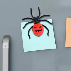 Close-up detail shot of the 3D printed Halloween spider fridge magnet on a blue sticky note.