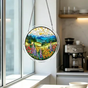 Close-up of round stained glass suncatcher hanging by chain in window, landscape art decor.