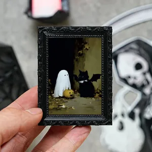 Gros plan du cadre photo miniature aimanté d'Halloween avec fantôme et chat noir mignon.