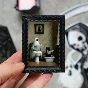 Gros plan sur le cadre photo miniature en résine avec fantôme et chat pour réfrigérateur.