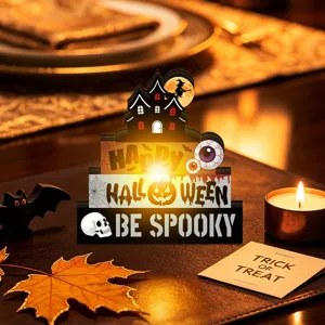 Detailed view of glowing wooden Halloween table decoration with haunted house and spooky elements.