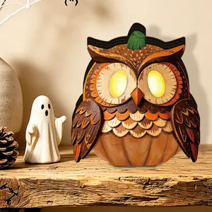 Close-up of the wooden Halloween glowing owl ornament featuring warm LED on rustic shelf.