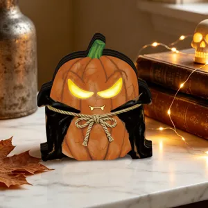 Close-up detail of the vintage Halloween glowing pumpkin ornament with vampire cape on table.