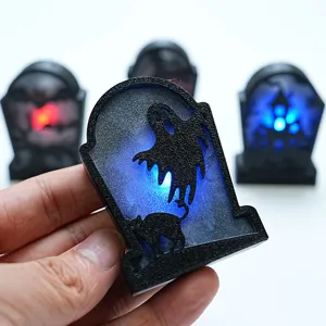 Halloween LED tombstone light detail closeup, spooky ghost and cat silhouette glowing nicely.
