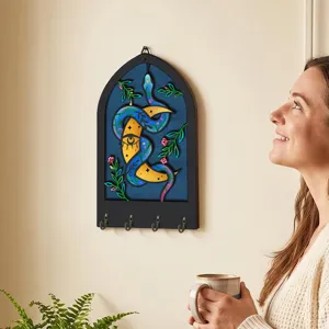 Bohemian wooden key holder wall decor with snake eye moon design and four metal hooks.