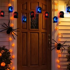 Halloween hanging LED tombstone and glowing pumpkin string lights scene decor detail view.