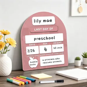 Roze acryl bord detailweergave voor de eerste schooldag geplaatst op houten bureau.