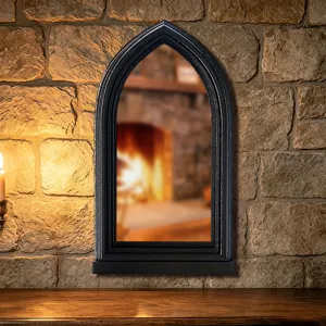 Gothic arched window mirror for home decor, vintage black frame wall decor with reflection.
