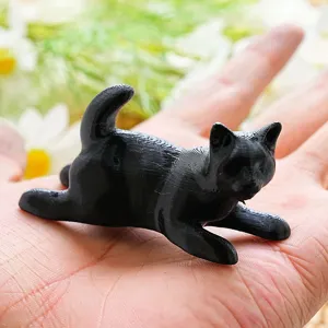 Detailed view of 3D printed black cat fridge magnet, showing realistic size and shape.