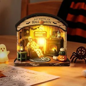 Detailed close-up of Halloween wooden miniature diorama with warm LED lights and glowing pumpkins.