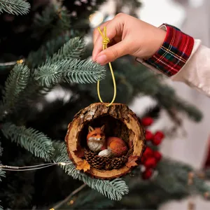 Christmas tree hanging ornament featuring a cute miniature sleeping fox inside a realistic tree hole.