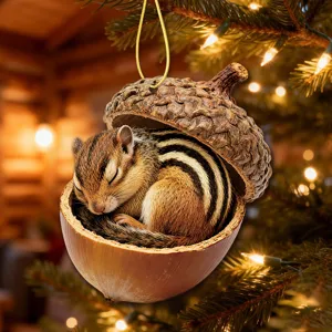 Close-up detail of cute sleeping chipmunk inside acorn shell ornament hanging on tree.