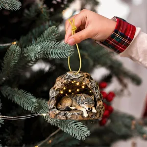 Christmas tree hanging ornament featuring a detailed wolf inside a glowing cave with lights.