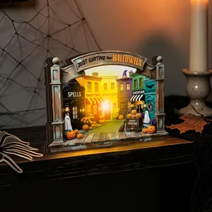 Halloween glowing wooden tabletop decoration detail featuring mini spooky autumn shops street scene.
