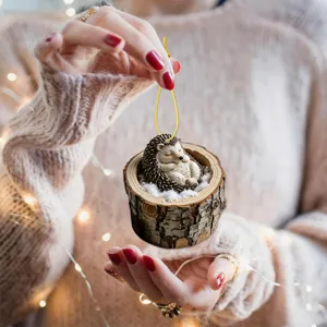 Charming sleeping hedgehog tree hole hanging ornament for festive holiday decor and tree display.