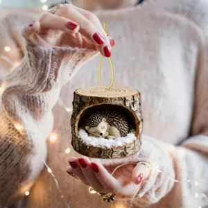 Close-up of a cute sleeping hedgehog in tree stump acrylic hanging ornament, winter holiday decor