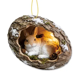 Detailed view of the resin rabbit tree hollow hanging ornament with snow, moss, and warm light inside.