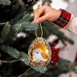Cute sleeping owl tree hole hanging ornament with warm fairy lights for Christmas decor.