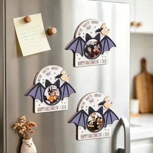 Detailed view of Halloween magnetic bat photo frames attached on refrigerator surface.
