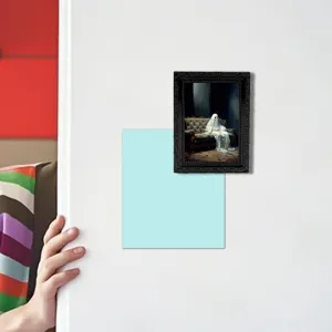 Close-up detail view of Halloween ghost magnetic photo frame and memo pad on white wall surface.