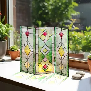Détail d'un paravent pliable miniature en acrylique translucide aux motifs géométriques colorés.