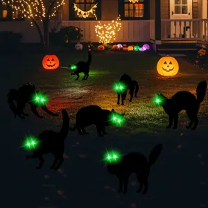 Glowing green eyes of black cat garden stakes creating spooky nighttime Halloween lawn scene.