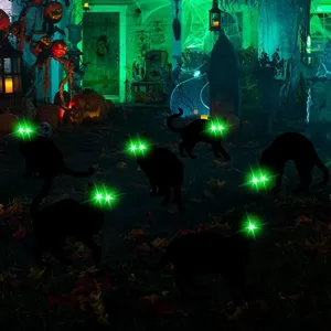 Halloween glowing black cat yard stakes detail shot showing eerie green LED eyes in spooky garden.