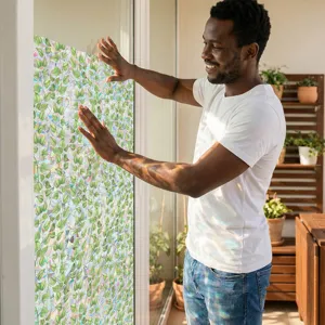Lifestyle detail shot of green leaf pattern static window privacy film with rainbow light effect.